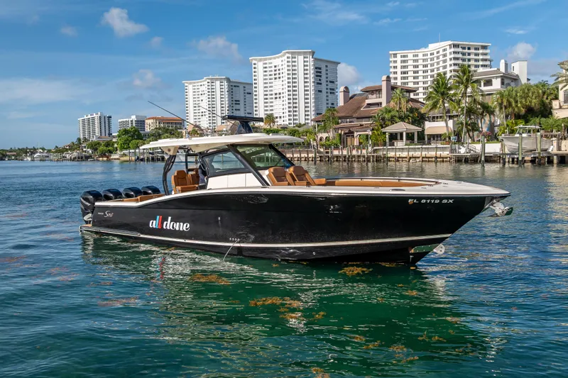  Yacht Photos Pics 2021 Scout 380 LXF boat on water with cityscape background.