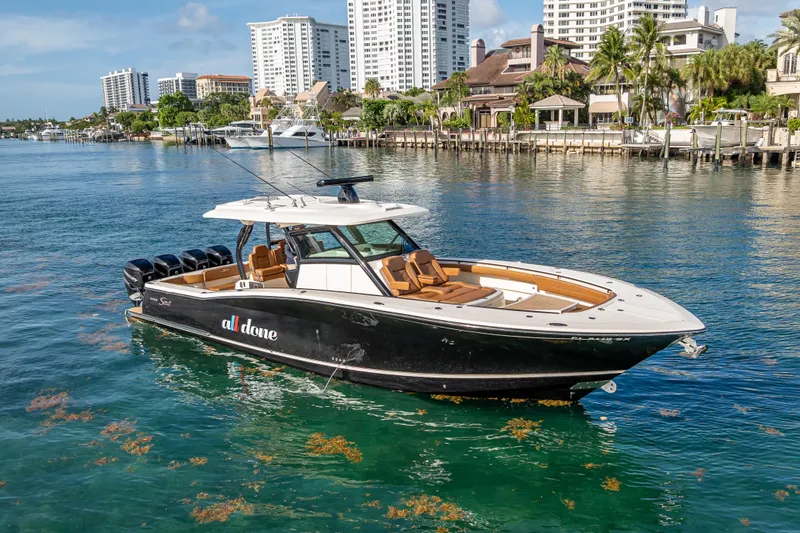  Yacht Photos Pics 2021 Scout 380 LXF boat on water, city skyline in background.