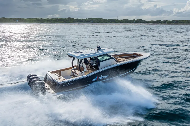  Yacht Photos Pics 2021 Scout 380 LXF boat cruising on open water under cloudy skies.