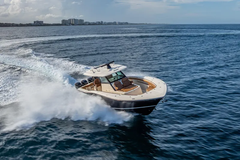  Yacht Photos Pics 2021 Scout 380 LXF boat cruising on open water, creating a dynamic wake.