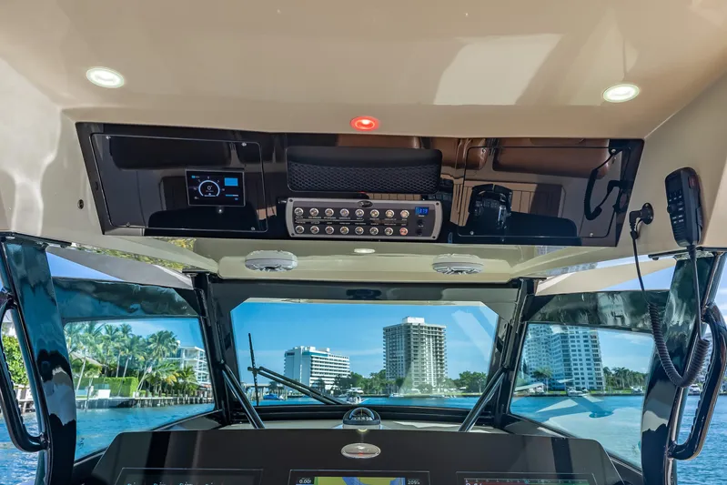  Yacht Photos Pics Interior view of 2021 Scout 380 LXF boat cockpit with modern controls and cityscape background.