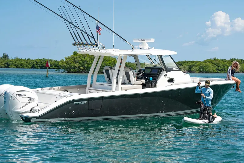  Yacht Photos Pics Manufacturer Provided Image: 2025 Pursuit S 358 Sport boat on water with fishing rods and paddleboarder nearby.