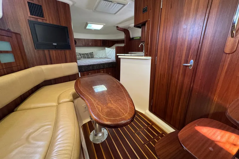 Pescador Yacht Photos Pics Luxurious interior of 2011 Pursuit OS 375 Offshore boat with wood finishes and seating area.