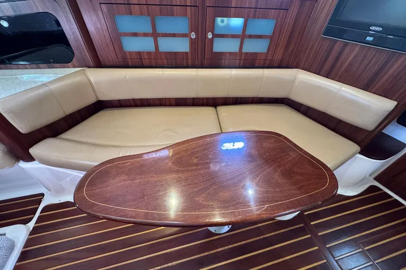 Pescador Yacht Photos Pics Luxurious interior of 2011 Pursuit OS 375 Offshore with leather seating and wooden table.