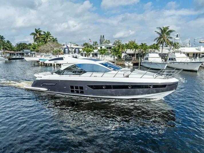 Blessed Yacht Photos Pics 2020 Azimut S6 yacht cruising on a sunny day, surrounded by palm trees and other boats.