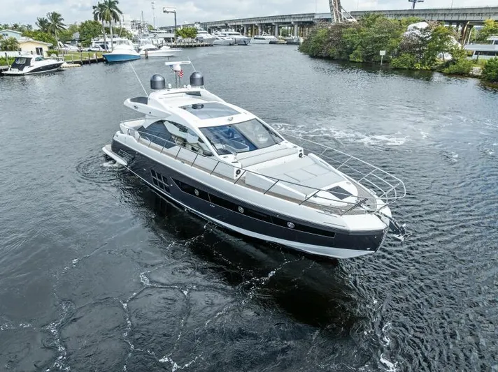 Blessed Yacht Photos Pics 2020 Azimut S6 yacht cruising in a marina, surrounded by other boats and lush greenery.