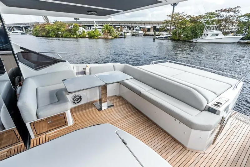 Blessed Yacht Photos Pics 2020 Azimut S6 yacht deck with seating and table, overlooking a serene waterfront.