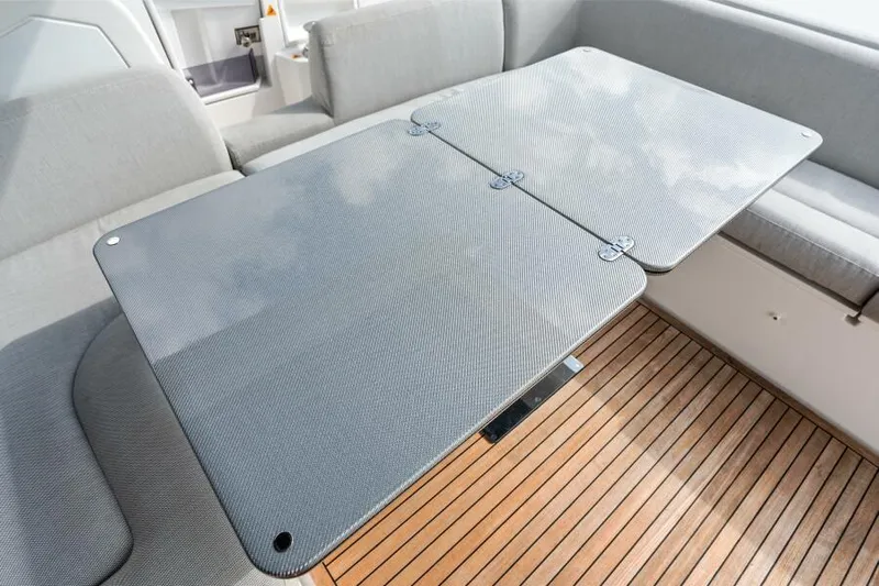 Blessed Yacht Photos Pics Azimut S6 2020 yacht interior with sleek table and cushioned seating on wooden deck.