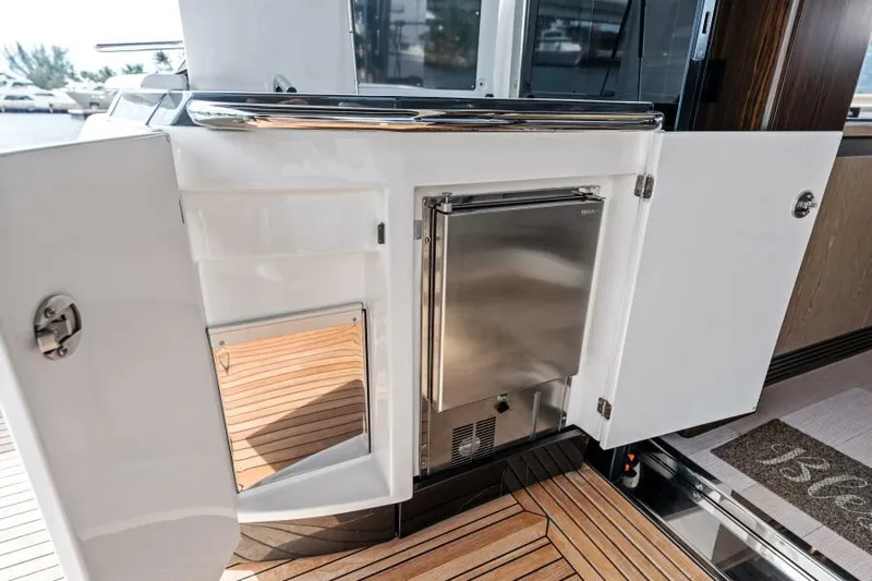 Blessed Yacht Photos Pics 2020 Azimut S6 yacht interior with open cabinet and stainless steel fridge.