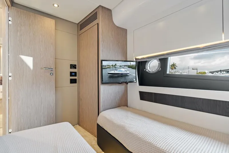 Blessed Yacht Photos Pics Interior of 2020 Azimut S6 yacht cabin with twin beds and a window view.