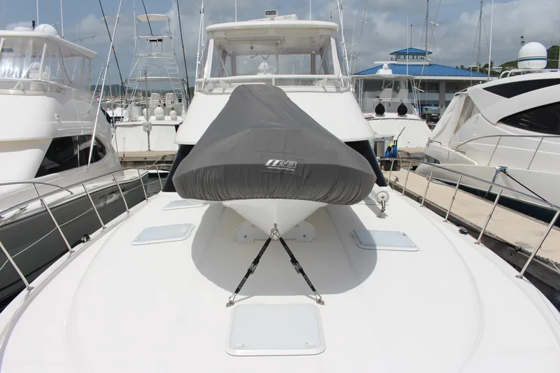  Yacht Photos Pics 2005 Riviera 51 Flybridge yacht docked at marina, bow view with covered equipment.