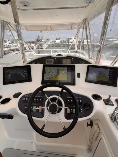  Yacht Photos Pics 2005 Riviera 51 Flybridge helm with advanced navigation systems and marina view.
