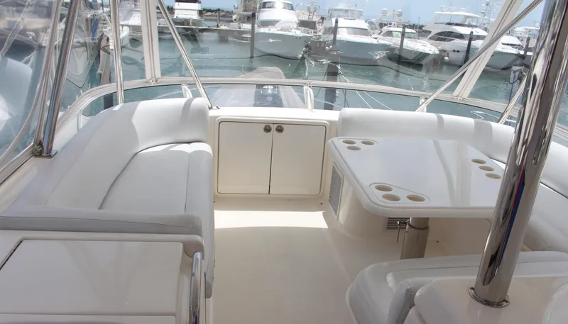  Yacht Photos Pics 2005 Riviera 51 Flybridge yacht interior with white seating and table, docked at marina.