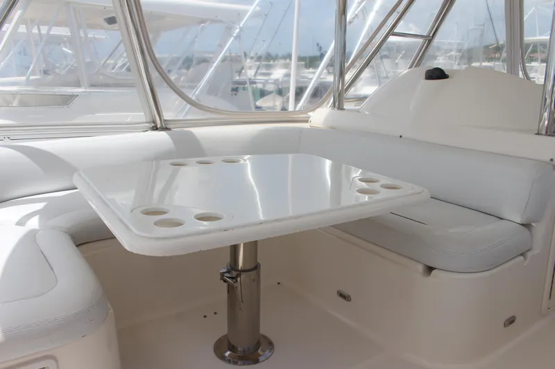  Yacht Photos Pics 2005 Riviera 51 Flybridge interior seating area with table and cup holders.