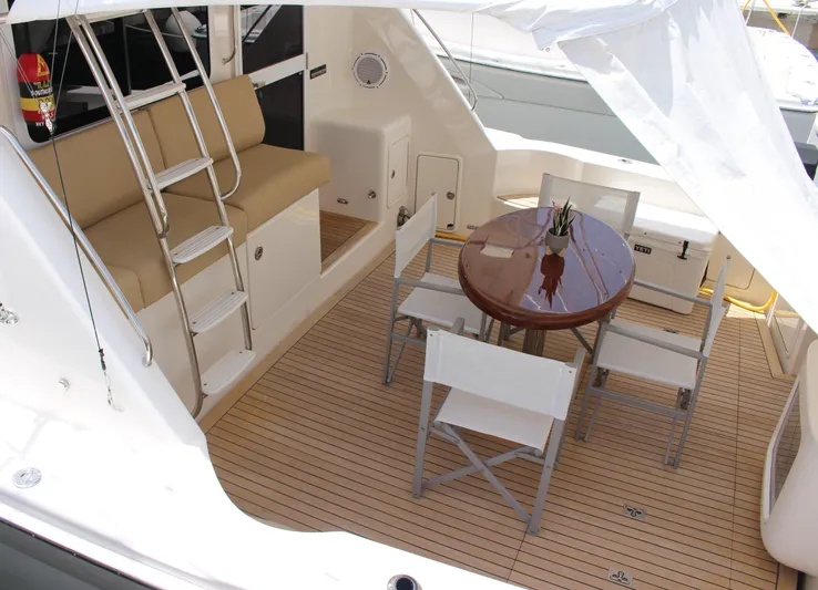 Yacht Photos Pics Outdoor seating area on 2005 Riviera 51 Flybridge yacht with table and chairs.