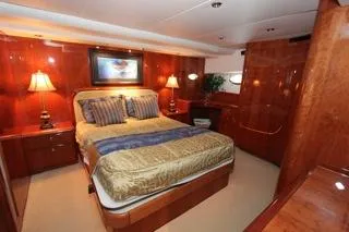Mabel Yacht Photos Pics Luxurious bedroom in a 2001 Precision Convertible yacht with elegant wood finishes.