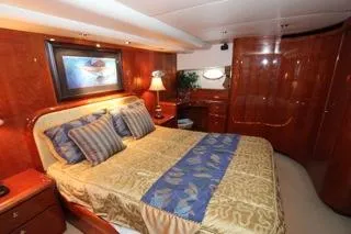 Mabel Yacht Photos Pics Luxurious bedroom in a 2001 Precision Convertible yacht with elegant wood finishes.