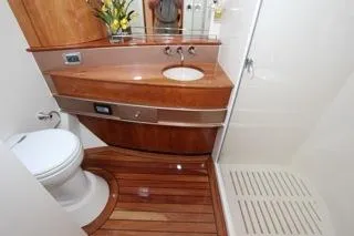 Mabel Yacht Photos Pics 2001 Precision Convertible yacht bathroom with wooden cabinetry and flooring.