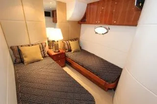 Mabel Yacht Photos Pics 2001 Precision Convertible yacht twin bed cabin interior with wooden accents and bedside lamp.