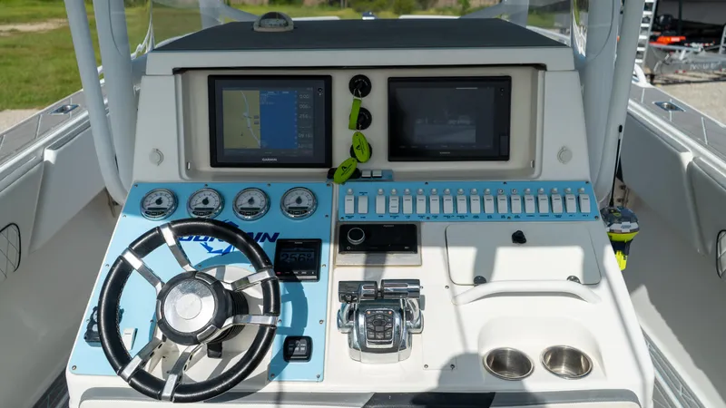  Yacht Photos Pics 2007 Fountain 38TE Cuddy Cabin helm with steering wheel, gauges, and navigation screens.