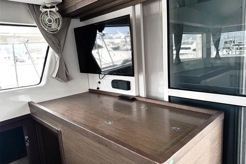 Coquina Yacht Photos Pics Interior of 2019 Lagoon 40 catamaran with TV and wooden cabinetry.