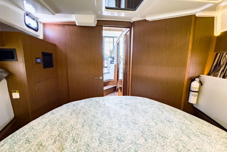 4761ak Yacht Photos Pics 2021 Jeanneau NC 1095 FLY cabin interior with bed and wooden finish.