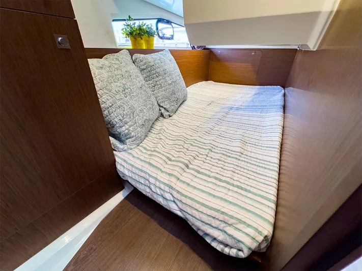 4761ak Yacht Photos Pics Cozy cabin bed in 2021 Jeanneau NC 1095 FLY yacht with striped bedding and decorative pillows.
