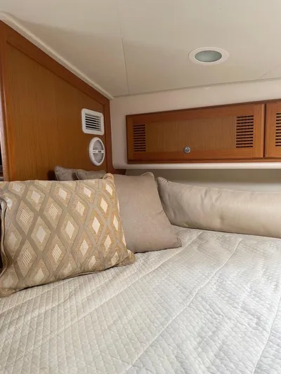  Yacht Photos Pics Cozy cabin interior of 2004 Cabo 35 Express with cushions and wood paneling.