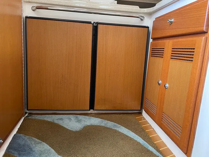  Yacht Photos Pics 2004 Cabo 35 Express interior with wooden cabinets and carpeted floor.
