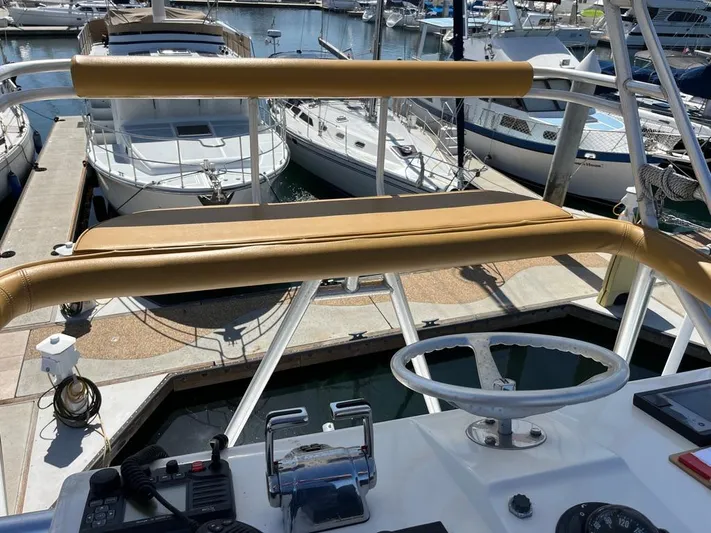  Yacht Photos Pics Helm of 2004 Cabo 35 Express yacht docked at marina, featuring steering wheel and controls.