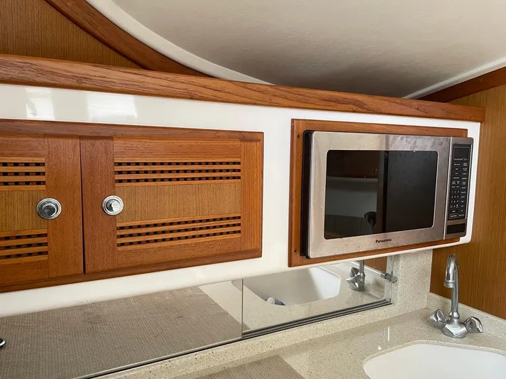  Yacht Photos Pics 2004 Cabo 35 Express yacht interior with wooden cabinets and built-in microwave.