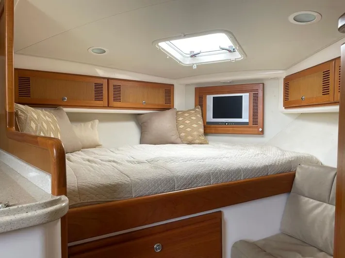  Yacht Photos Pics Luxurious cabin interior of 2004 Cabo 35 Express yacht with cozy bed and TV.