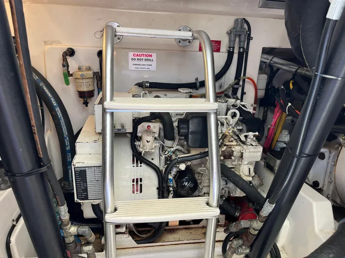  Yacht Photos Pics Engine compartment of a 2004 Cabo 35 Express boat with visible machinery and ladder.