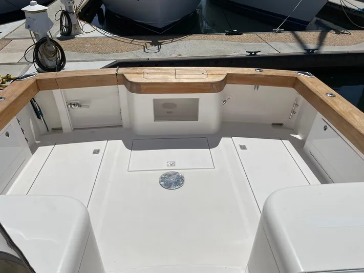  Yacht Photos Pics 2004 Cabo 35 Express boat deck with wooden trim, docked at marina.