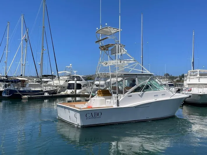  Yacht Photos Pics 2004 Cabo 35 Express boat docked in a marina, surrounded by other yachts.