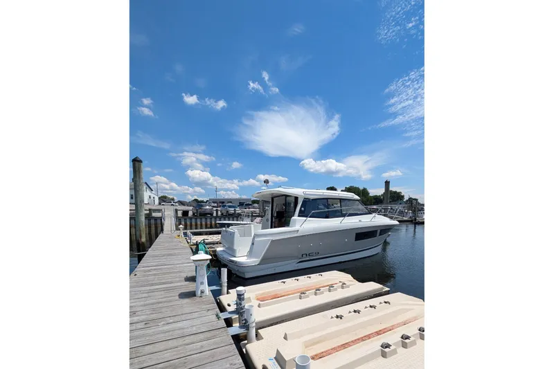  Yacht Photos Pics 2019 Jeanneau NC 9 docked at marina under clear blue sky.