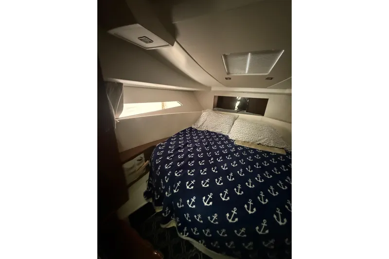  Yacht Photos Pics Cozy cabin interior of 2019 Jeanneau NC 9 with anchor-patterned bedding.