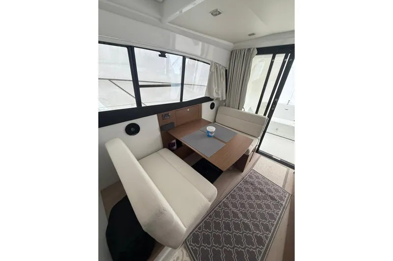  Yacht Photos Pics Interior of 2019 Jeanneau NC 9 boat with cozy seating and table.