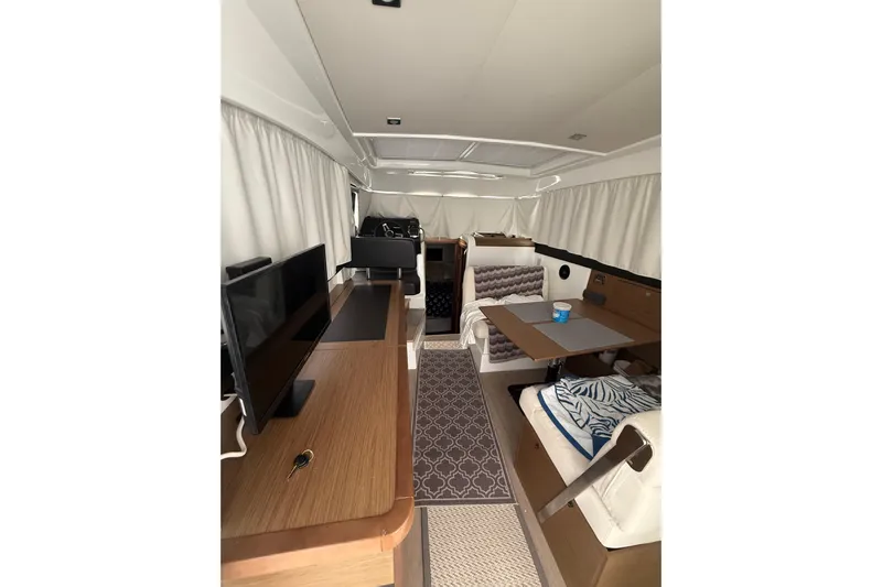  Yacht Photos Pics Interior of 2019 Jeanneau NC 9 boat with modern furnishings and cozy seating area.