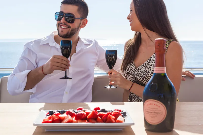 Salacia Yacht Photos Pics Couple enjoying champagne and fruit on a Sirena 64 yacht, 2019 model, with ocean view.