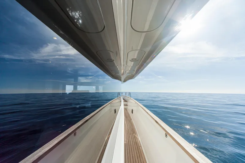 Salacia Yacht Photos Pics 2019 Sirena 64 yacht reflecting on calm ocean waters under a clear sky.