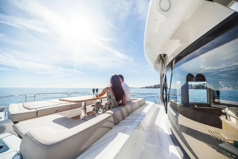 Salacia Yacht Photos Pics Couple relaxing on Sirena 64 yacht, enjoying sunny ocean view, 2019 model.