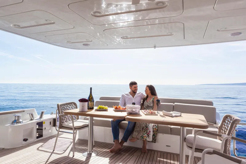 Salacia Yacht Photos Pics Couple enjoying a meal on a 2019 Sirena 64 yacht, with ocean view.