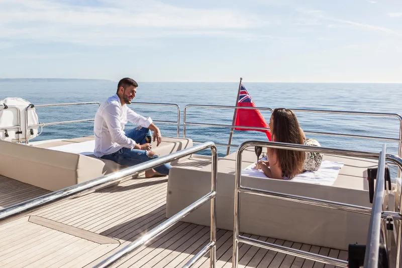 Salacia Yacht Photos Pics Couple relaxing on 2019 Sirena 64 yacht deck, enjoying ocean view and sunshine.
