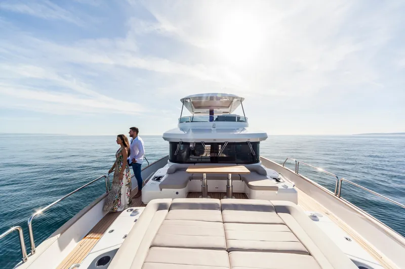 Salacia Yacht Photos Pics Couple enjoying a sunny day on a 2019 Sirena 64 yacht at sea.