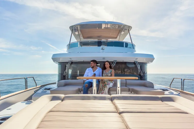 Salacia Yacht Photos Pics Couple relaxing on 2019 Sirena 64 yacht, enjoying ocean view under clear sky.