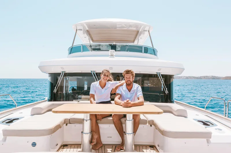 Salacia Yacht Photos Pics Couple relaxing on 2019 Sirena 64 yacht deck, enjoying sunny ocean view.