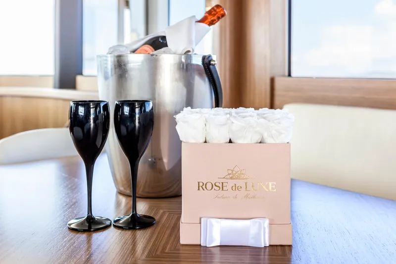 Salacia Yacht Photos Pics Luxury yacht interior with champagne, black glasses, and white roses on a Sirena 64, 2019.