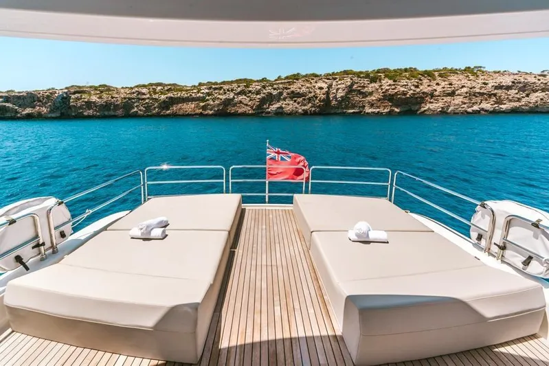 Salacia Yacht Photos Pics Luxurious Sirena 64 yacht deck with sunbeds, overlooking serene blue waters, 2019 model.
