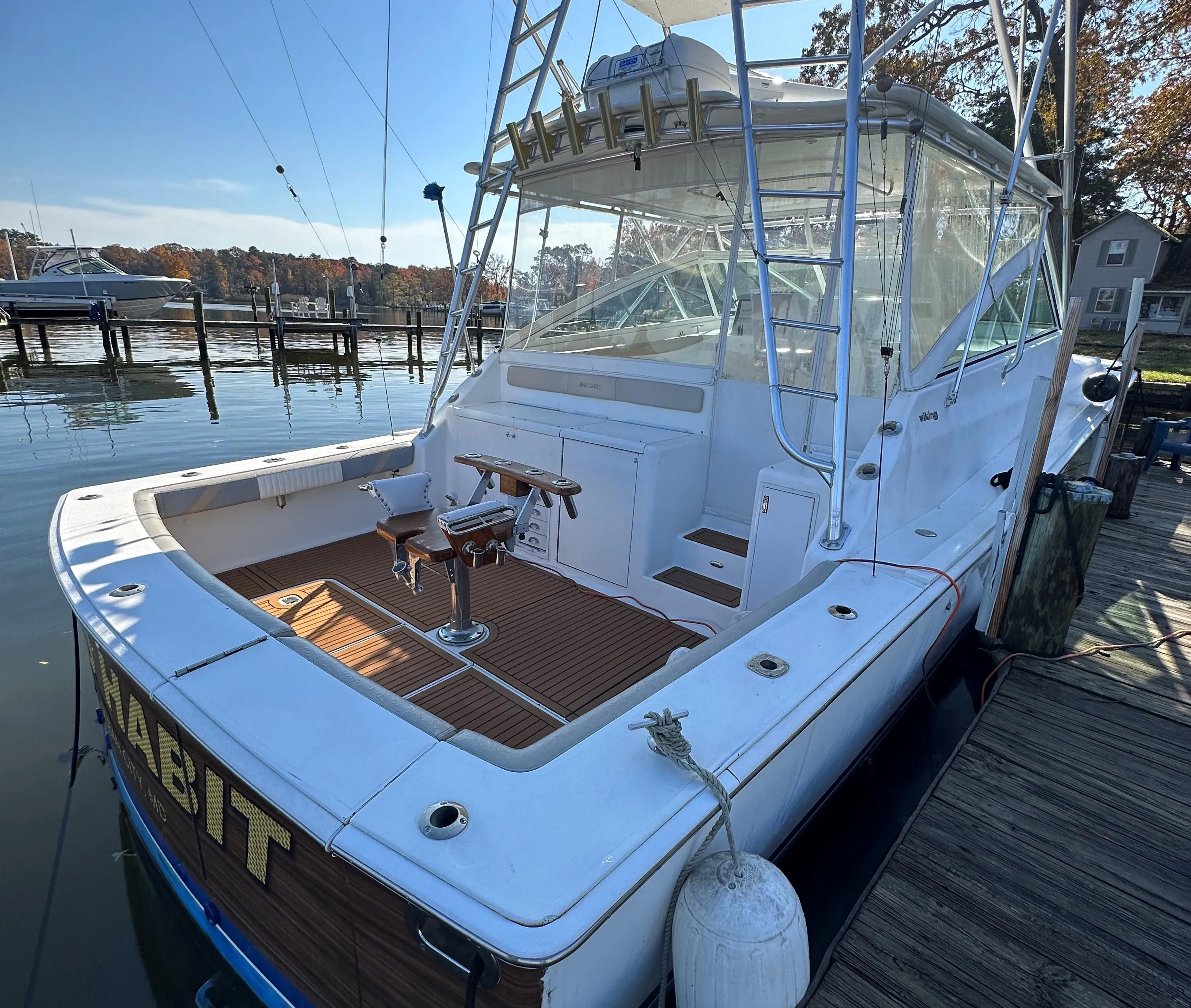 1997 Viking 43 Open boat docked, rear view with fishing tower and clear skies.